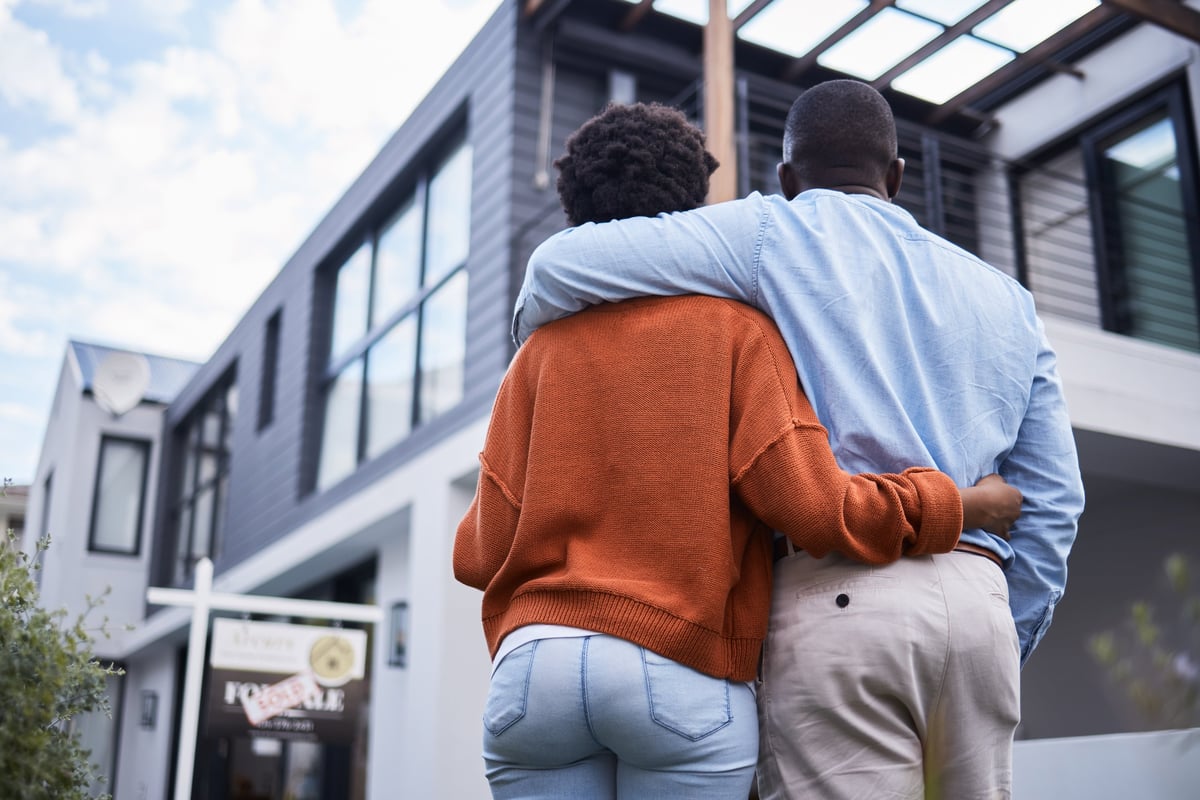 Homeowners standing outside their home in the neighbourhood of their dreams