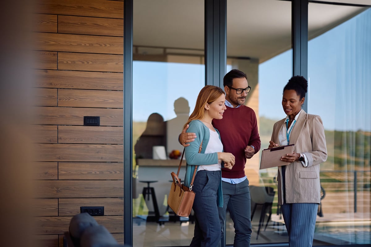Real estate agent reviewing housing plans with a couple buying a new home